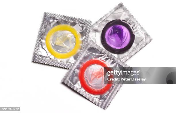 three coloured condoms - condon fotografías e imágenes de stock