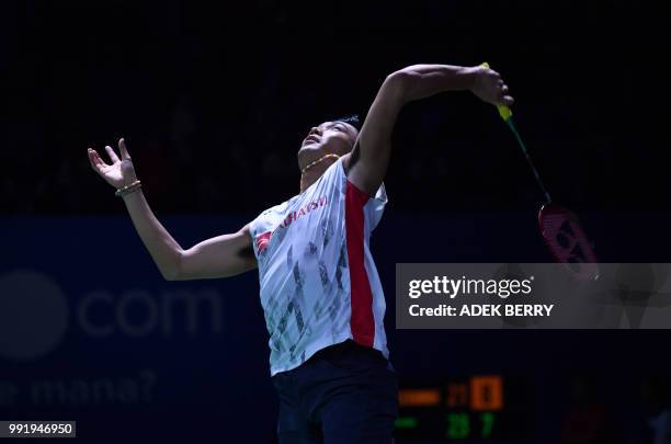Kento Momota of Japan plays a return against Anthony Sinisuka Ginting of Indonesia during the men's singles badminton match at the Indonesia Open in...