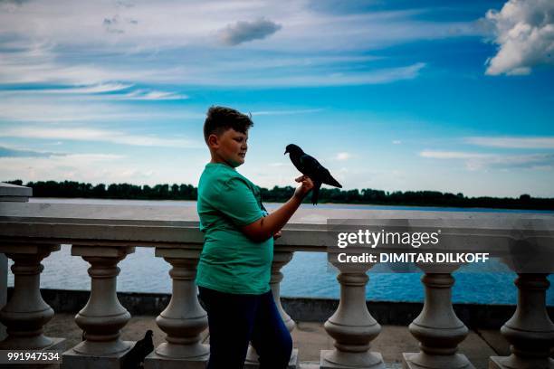 Boy holds a dove on the bank of the Volga river in Nizhny Novgorod, on July 4, 2018. Nizhny Novgorod stadium will host on July 6, 2018 the...