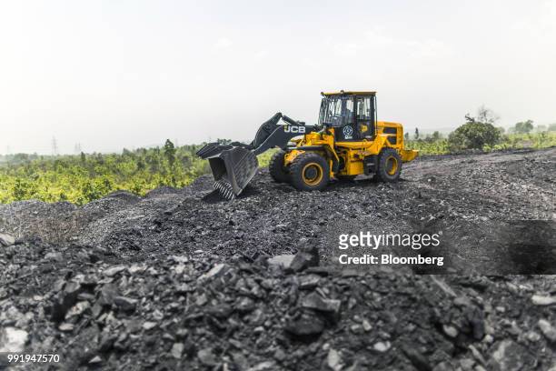 Bamford Excavators Ltd. Front loader moves coal at the Tori Siding on the Tori-Shivpur rail line, operated by Indian Railways and funded by Coal...