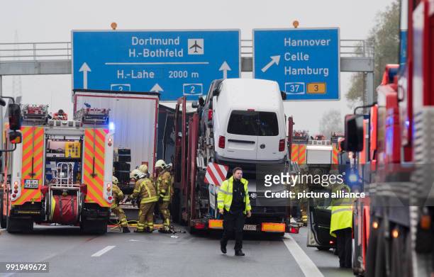 Firefighters and police officers stand on the motorway A2 after an accident at the motorway junction Hanover Buchholz, Germany, 21 November 2017....