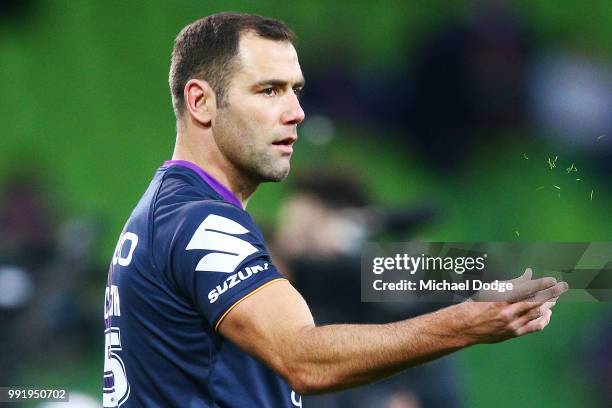 Cameron Smith of the Storm throws blades of grass to test the wind in the warm up during the round 17 NRL match between the Melbourne Storm and the...