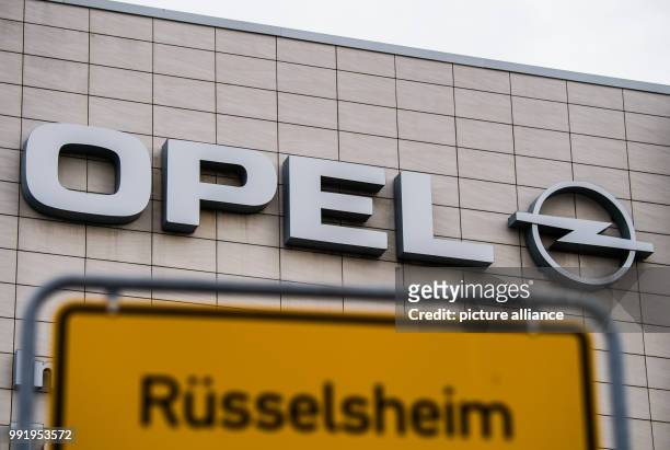 July 2018, Ruesselsheim, Germany: The town sign of "Ruesselsheim" can be seen in front of the Opel logo. The French Opel owner PSA apparently wants...