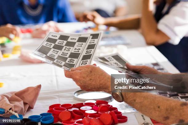 cerca senior mans manos repartiendo cartas para un juego de bingo - bingo fotografías e imágenes de stock