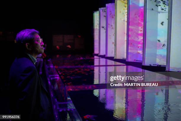 Man looks at goldfish during a press preview of the 2018 EDO Nihonbashi Art Aquarium exhibition in Tokyo on July 5, 2018. / "The erroneous mention[s]...