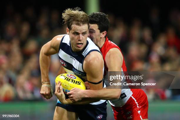 Jake Kolodjashnij of the Cats is tackled during the round 16 AFL match between the Sydney Swans and the Geelong Cats at Sydney Cricket Ground on July...