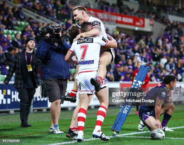 Dragons players celebrate after Kurt Mann of the Dragons scores a try past Jahrome Hughes of the Storm during the round 17 NRL match between the...