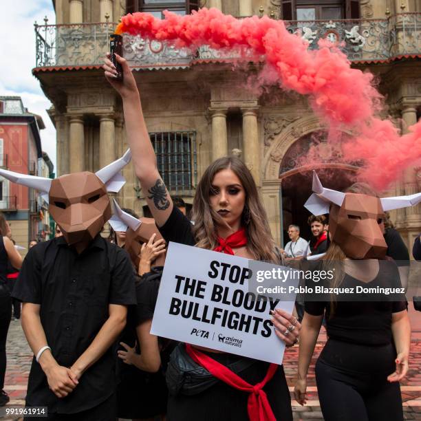 Animal rights activists protest against bullfights holding a placard reading 'Stop the bloody bullfights' ahead of San Fermin Running of the bulls at...