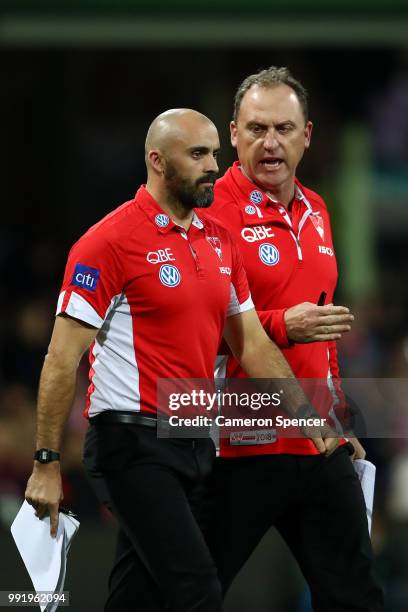 Swans head coach, John Longmire talks to assistant coach Rhyce Shaw during the round 16 AFL match between the Sydney Swans and the Geelong Cats at...