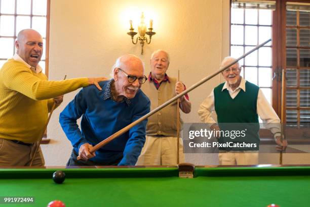 senior woman jubelten und klopfte auf der rückseite von jüngeren freund wie er den billard-ball in der tasche sinkt - snookerkugel stock-fotos und bilder