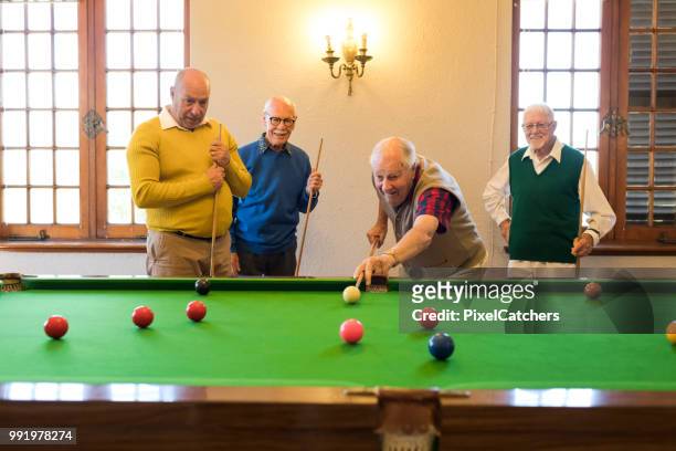 active senior man hard at concentration as he takes a shot at snooker - snooker ball stock pictures, royalty-free photos & images