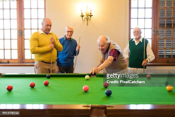 retirement lifestyle of senior men enjoying their weekend game of billiards - snooker ball stock pictures, royalty-free photos & images