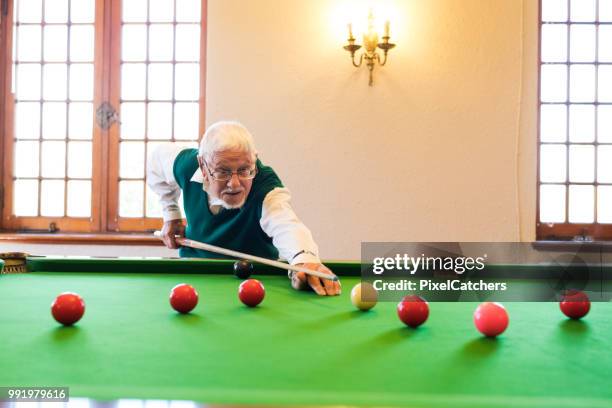 grey haired senior man takes aim with snooker cue - snooker ball stock pictures, royalty-free photos & images