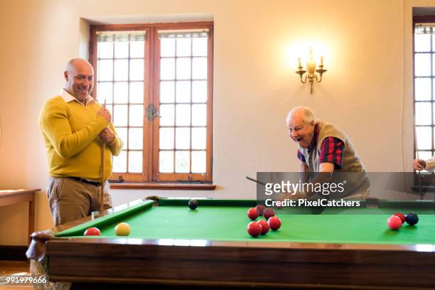 unbeschwerte senior männer spielen snooker im innenbereich - snookerkugel stock-fotos und bilder