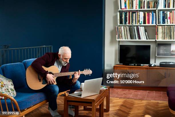 senior man learning to play guitar with laptop - make music day stock pictures, royalty-free photos & images
