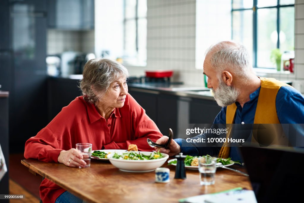 Senior couple having serious discussion over lunch at home