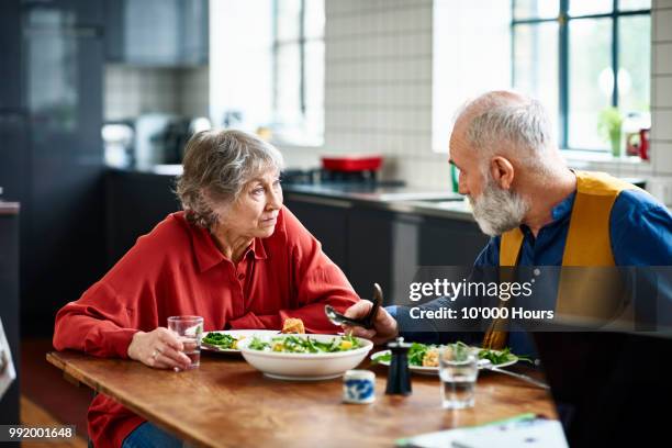 senior couple having serious discussion over lunch at home - two people talking serious stock pictures, royalty-free photos & images