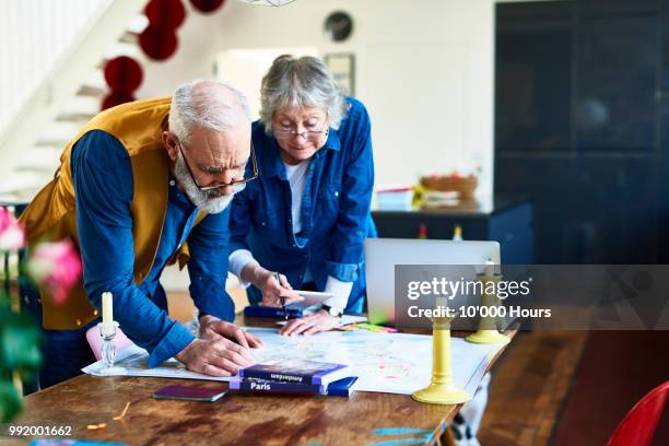 senior couple planning round the world adventure - young at heart stock pictures, royalty-free photos & images