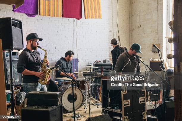 band practicing with musical instruments in recording studio - performance group stockfoto's en -beelden