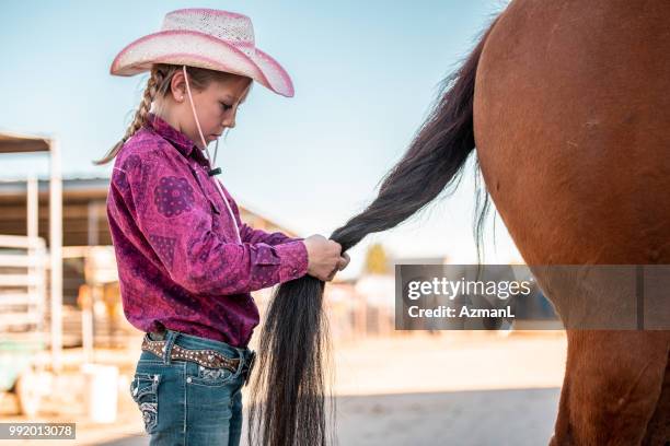 junge cowgirl flechten zöpfe auf pferdeschwanz - cowgirl hairstyles stock-fotos und bilder