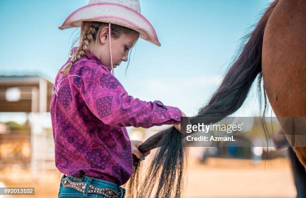 junge cowgirl flechten zöpfe auf pferdeschwanz - cowgirl hairstyles stock-fotos und bilder