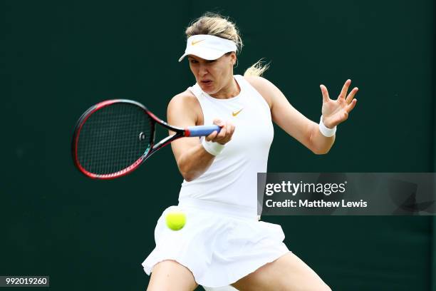 Eugenie Bouchard of Canada returns a shot to Ashleigh Barty of Australia during their Ladies' Singles second round match on day four of the Wimbledon...