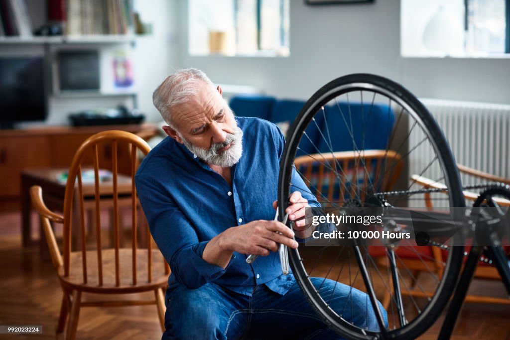 Senior man removing bicycle tyer to repair a puncture