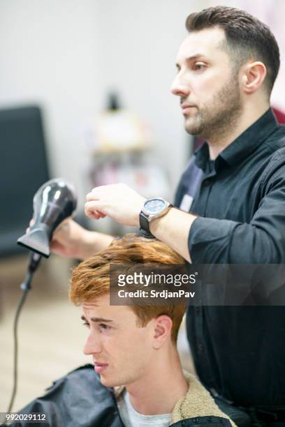 erschöpft friseur trocknen haare des kunden - matt barber stock-fotos und bilder