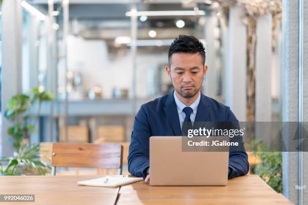 businessman using a laptop in a modern office - jgalione stock pictures, royalty-free photos & images