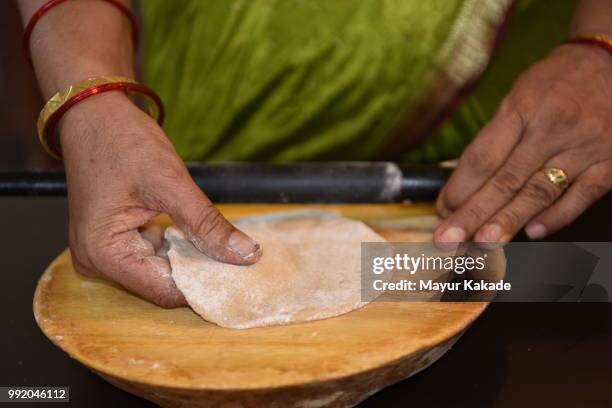 indian woman making chapatti (indian bread) - roti stock pictures, royalty-free photos & images