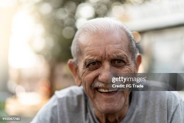 senior volwassen mannetje lachend portret; hij is 89 jaar oud - 90 years stockfoto's en -beelden
