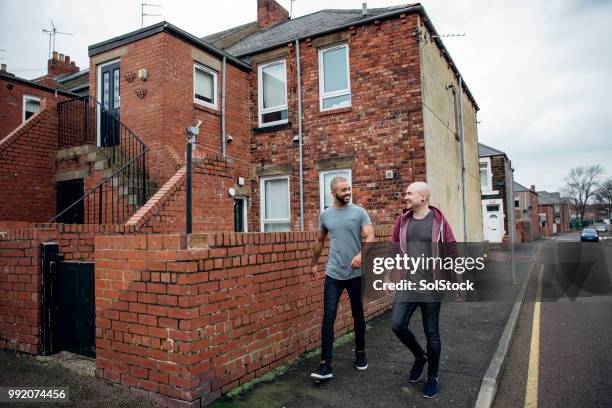 two men walking through a house estate - england tattoo stock pictures, royalty-free photos & images