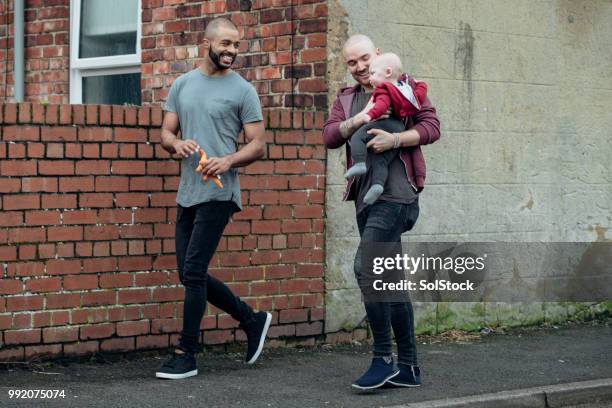 father's walking carrying their baby boy - cross road children stock pictures, royalty-free photos & images