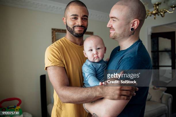 men at home with their son - multiracial person stock pictures, royalty-free photos & images