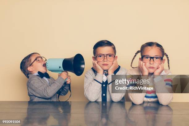 young nerd boy yelling at siblings with megaphone - sibling stock pictures, royalty-free photos & images