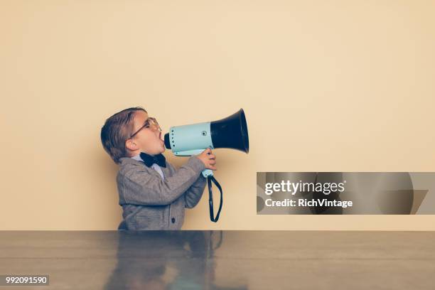 young nerd boy yells into megaphone - problemas de comunicação imagens e fotografias de stock