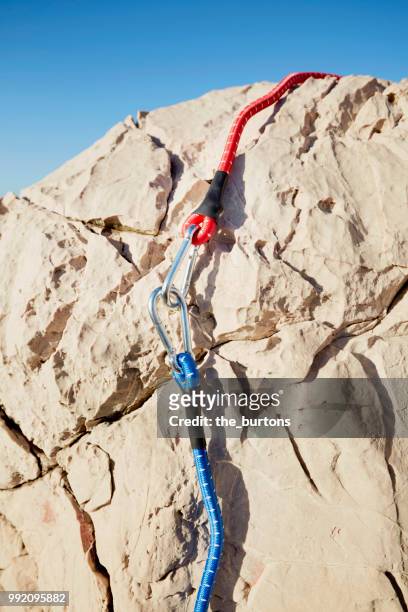 full frame shot of rock with fissures and carabiner with two colored rope - fastening stock-fotos und bilder