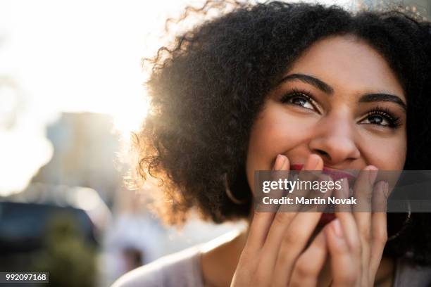 cheerful teen woman covering her mouth - surprize stock pictures, royalty-free photos & images