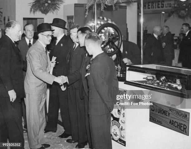 English motor manufacturer William Morris, 1st Viscount Nuffield congratulates the record-breaking Sturmey Archer team at the Cycle and Motor Cycle...