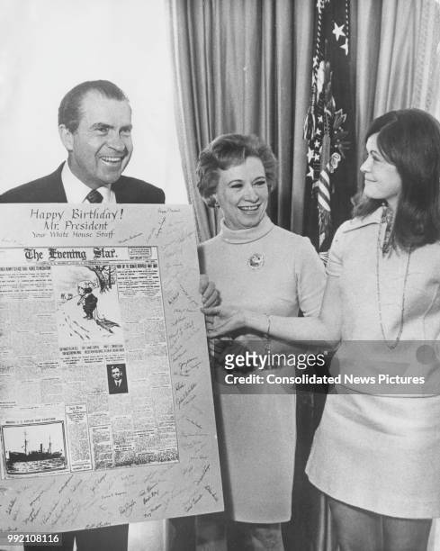 President Richard Nixon receives a large birthday card from his secretaries Rose Mary Woods and Terry Decker at the White House in Washington, DC,...