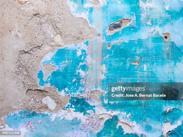 wall with peeling blue and white paint with cracks and dampness. - adobe texture stockfoto's en -beelden