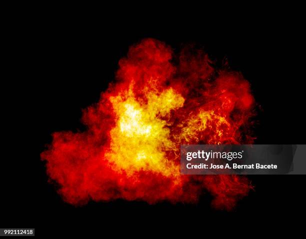full frame of forms and textures of an explosion of powder and smoke of color yellow and red on a black background. - fire explosion stock pictures, royalty-free photos & images