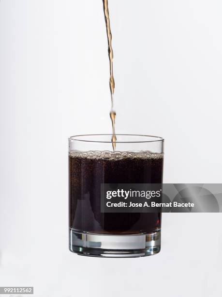 filling of a glass of crystal of soft-drink of cola, in front of white background. - high speed photography stock pictures, royalty-free photos & images