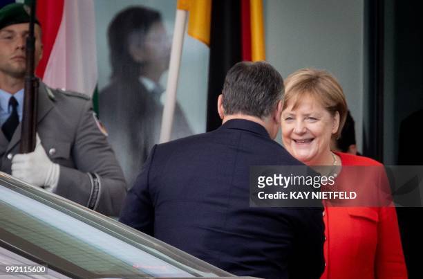 German Chancellor Angela Merkel welcomes Hungarian Prime Minister Viktor Orban before a meeting on July 5, 2018 in Berlin. - Angela Merkel and Viktor...