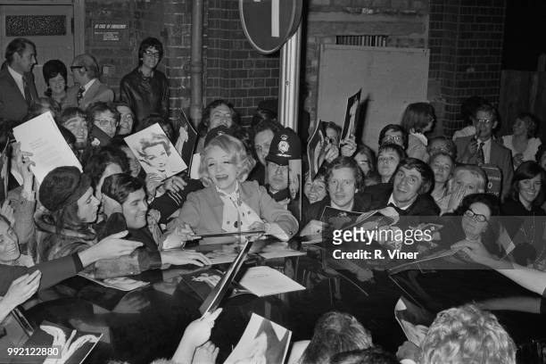 German actress and singer Marlene Dietrich laugh while being mobbed by enthusiastic fans as she leaves a theater in Birmingham, UK, 26th May 1973.