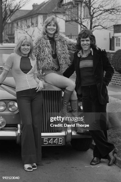 English singer-songwriter, musician, A&R manager, fundraiser and businessman Dave Dee with two young women, UK, 12th March 1973.