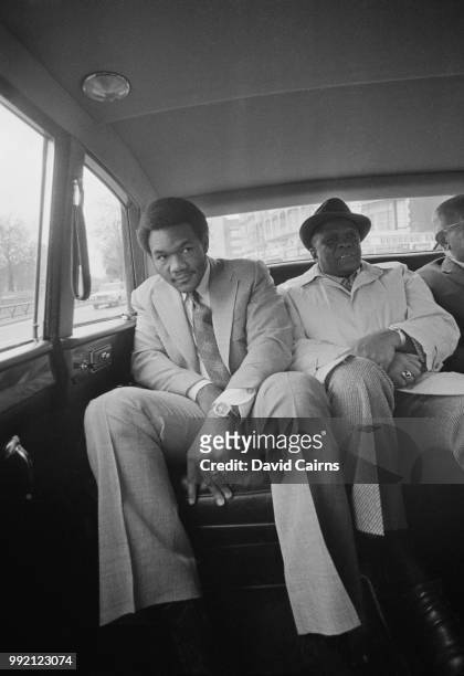 American boxer George Foreman sitting in the backseat of a car with his manager, 13th March 1973.
