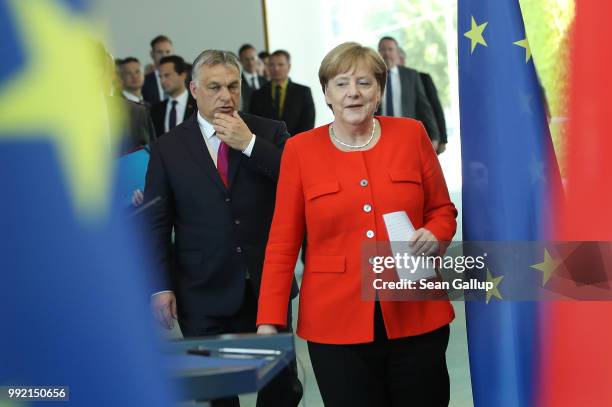 German Chancellor Angela Merkel and Hungarian Prime Minister Viktor Orban arrive to speak to the media following talks at the Chancellery on July 5,...