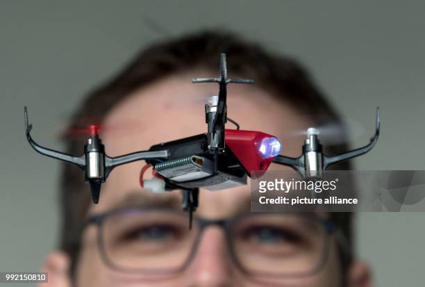 Bastian Hummel of the Graupner company flying a Graupner Alpha 110 drone in an aisle of the Stuttgart convention center during a photo shoot in...