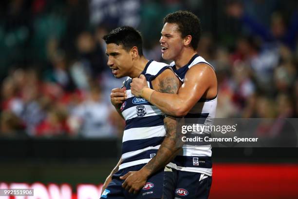 Tim Kelly of the Cats is congratulated by team mate Brandan Parfitt of the Cats during the round 16 AFL match between the Sydney Swans and the...